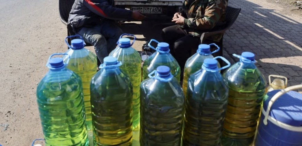 Serbia black market fuel sold in plastic bottles, color-coded by the country of origin